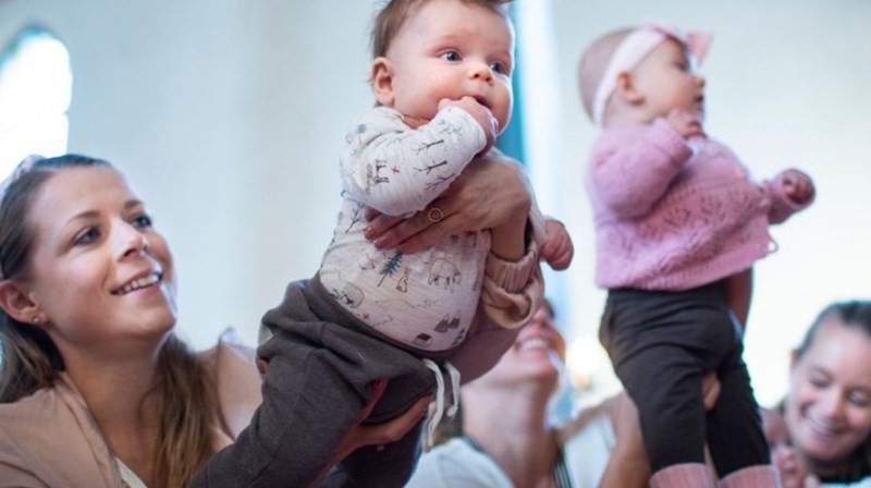 Bilde av baby som holdes opp